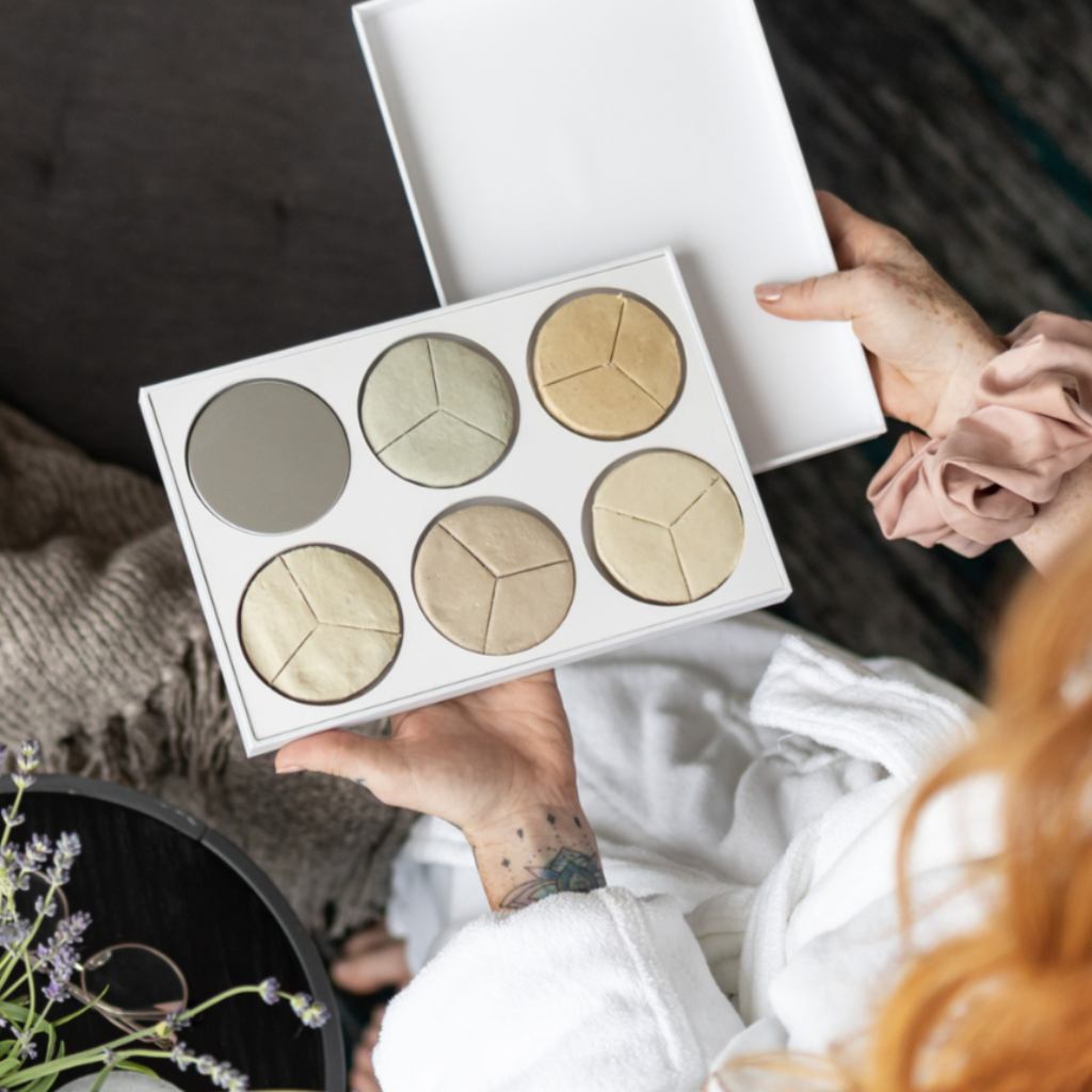 Woman opening Bubble Bath Therapy for Dry Skin kit from Bubbles & Balms