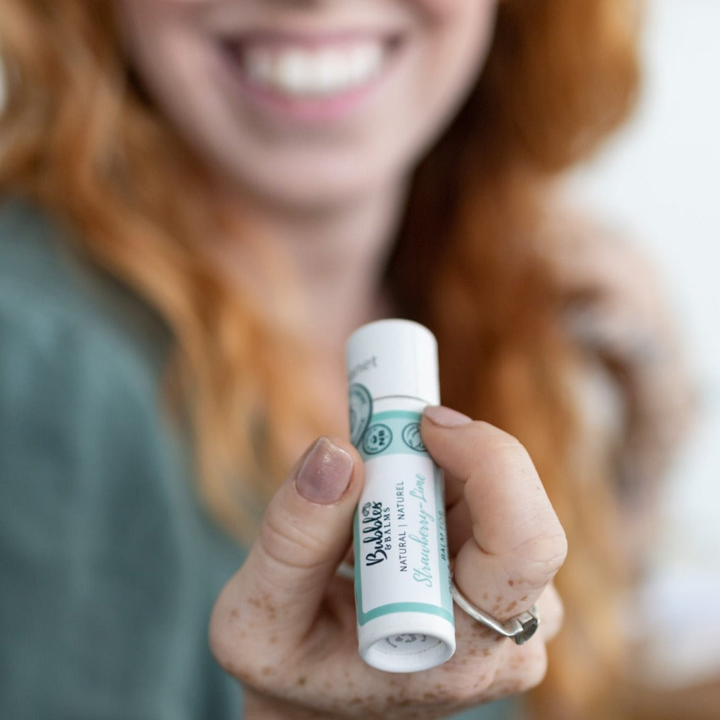 Woman getting ready to apply Bubble & Balms strawberry lime, vegan lip balm