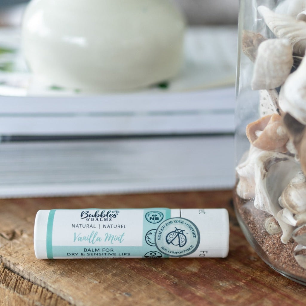 Bubbles & Balms vegan and plant-based Vanilla Mint lip balm next to seashells on rustic table