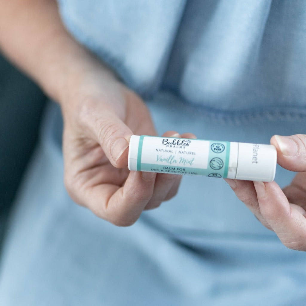 Vanilla Mint lip balm, a vegan, plastic-free, certified cruelty-free and plant-based option from Bubbles & Balms of Hampton, New Brunswick, being held by mother with sensitive skin.