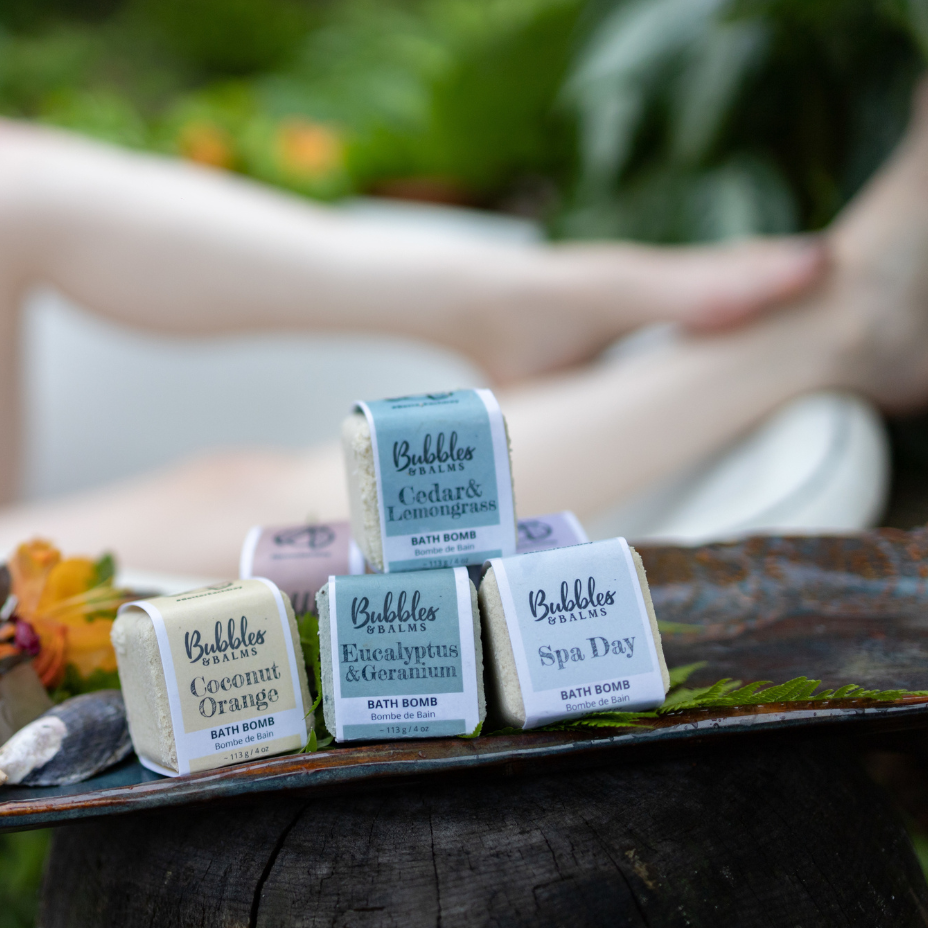 Bubbles & Balms Bath Bomb Collection With Women in Clawfoot Tub Posed Behind Them near Hampton, New Brunswick