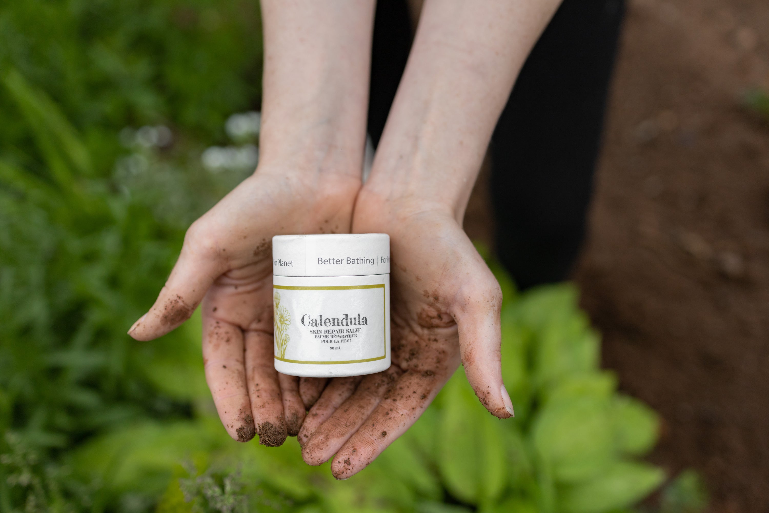 Bubbles & Balms Calendula Soothing Skin Salve for dry, cracked and inflamed skin being held in gardener's hands near Saint John, New Brunswick