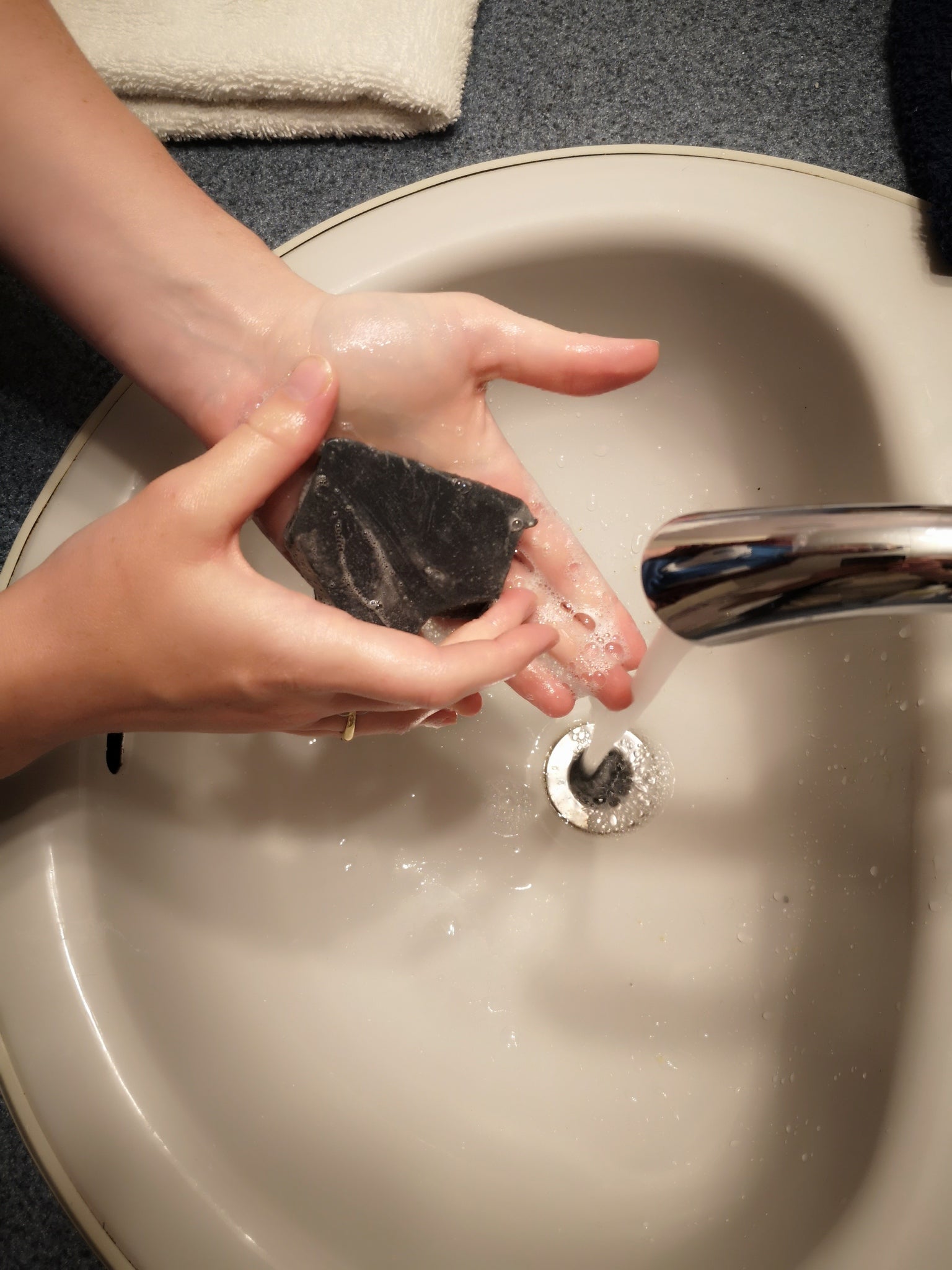 Overwashing with soap is one of the causes of dry skin and is shown in this image with a woman washing her hands.