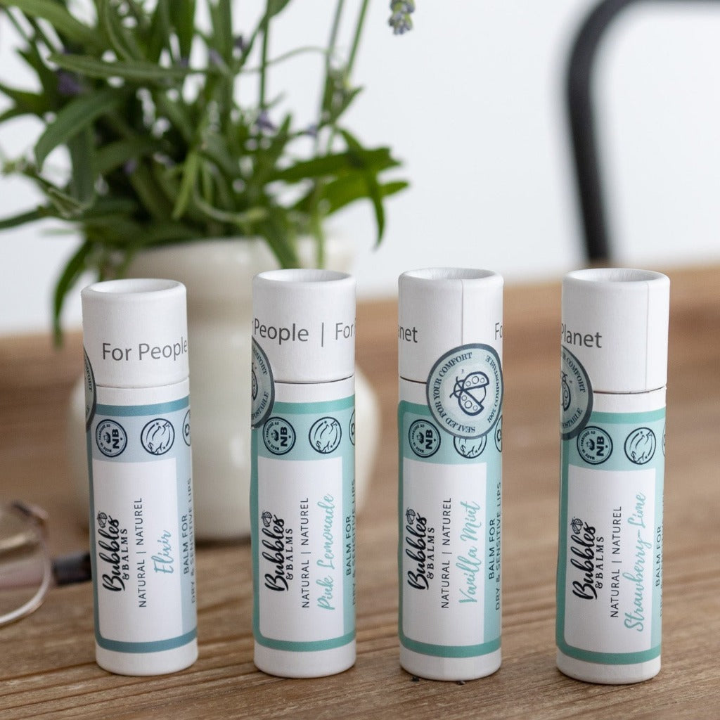 Collection of Bubbles &amp; Balms 4 Vegan lip balms for dry &amp; sensitive skin on a wooden table.