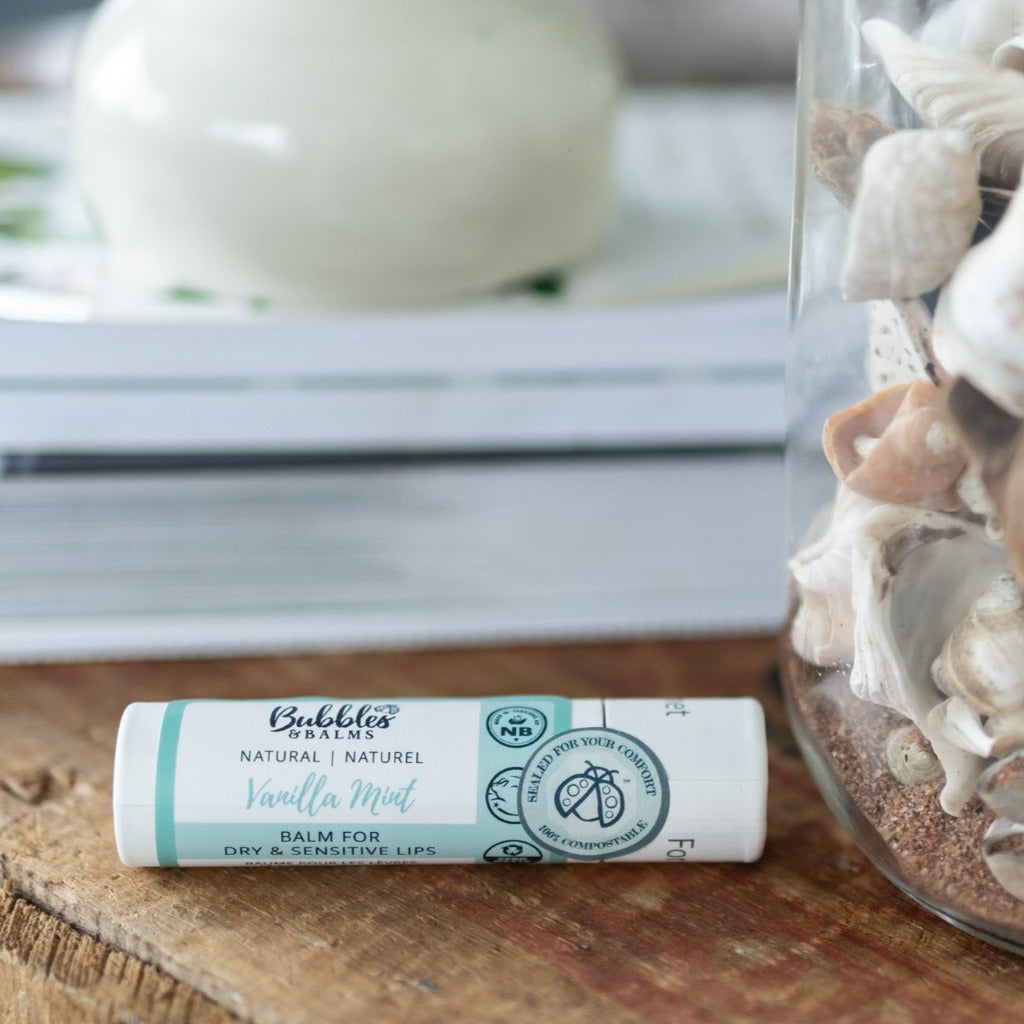 Bubbles &amp; Balms vegan and plant-based Vanilla Mint lip balm next to seashells on rustic table
