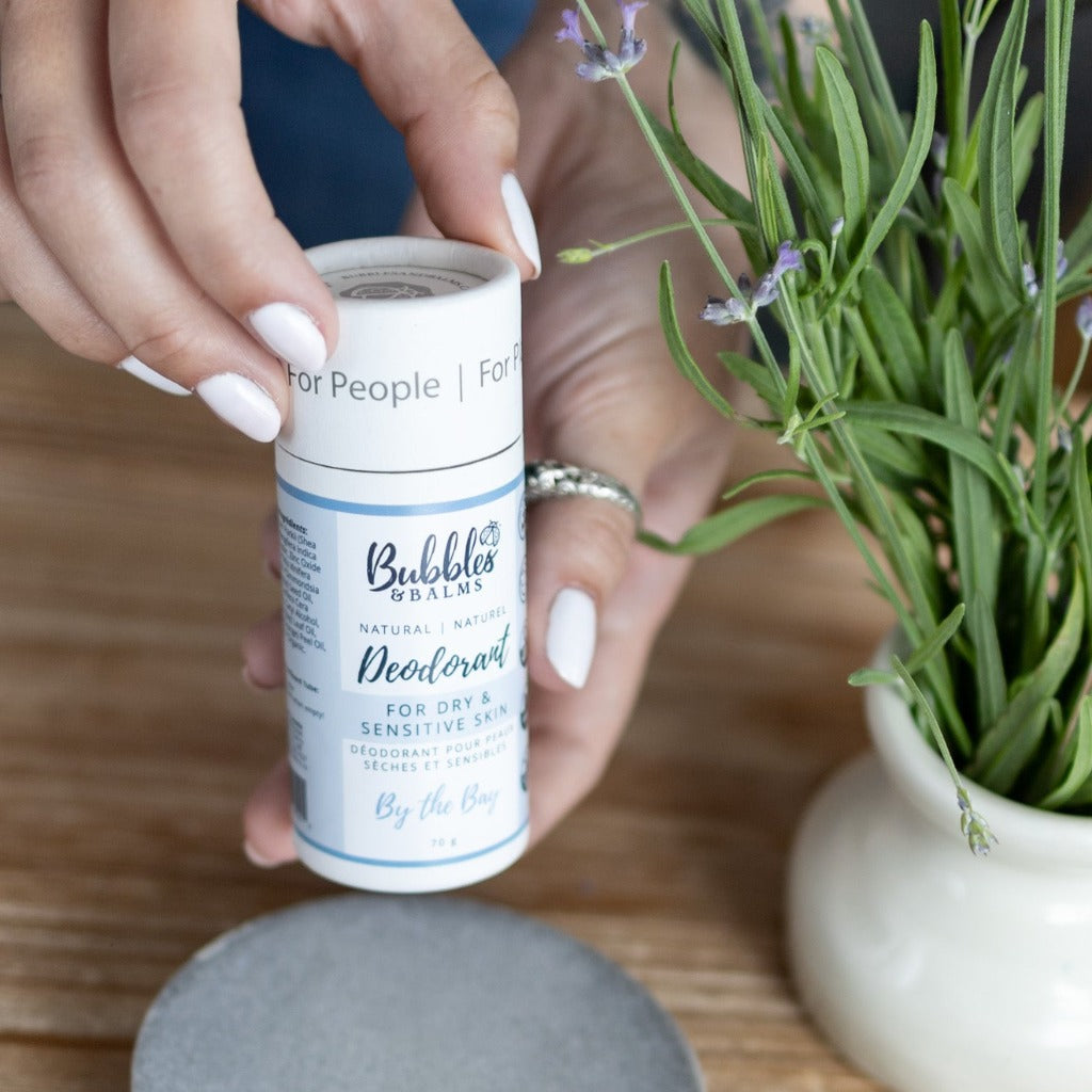 Woman holding zero-waste tube of natural By the Bay deodorant from Bubbles &amp; Balms.