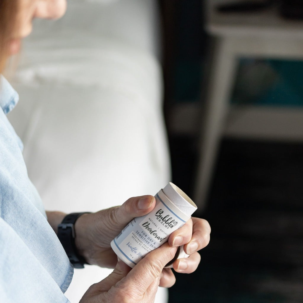 Woman reading list of natural ingredients in aluminum-free deodorant from Bubbles &amp; Balms.