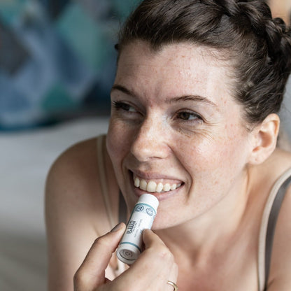 Woman applying Bubbles &amp; Balms vegan lip balm for dry &amp; sensitive lips.