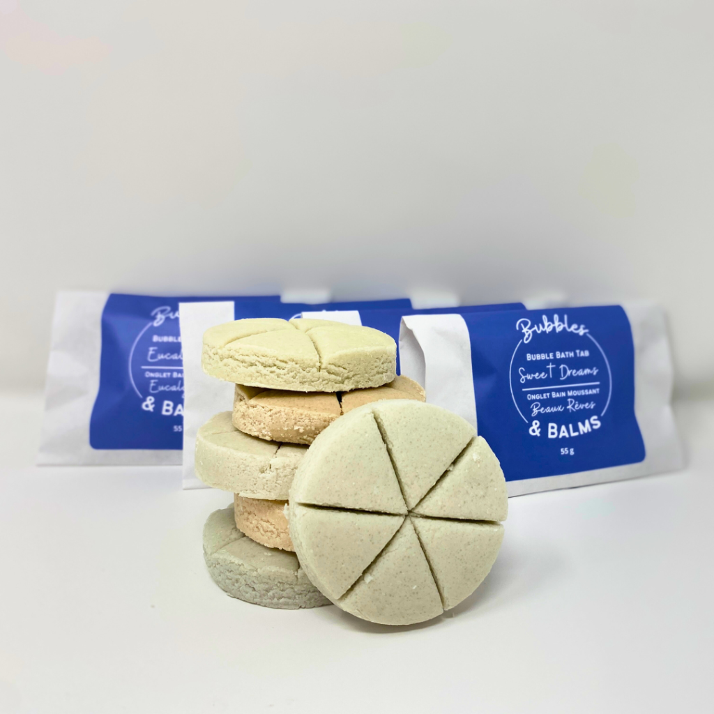 Bubbles & Balms solid bubble bath tabs for dry & sensitive skin with packaging in behind and bubble bath tab facing outwards with its 6 sections for mix & match aromas.