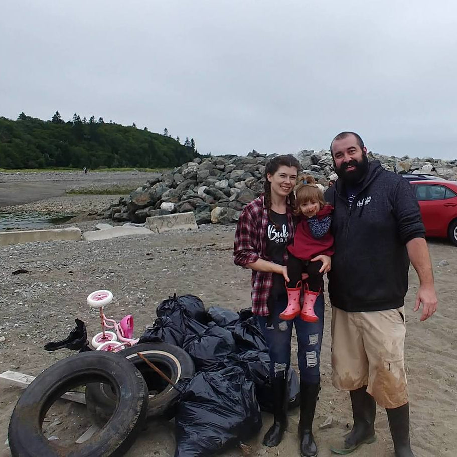 Bubbles & Balms Cofounders Judith & Justin Sweeney near Saint John, New Brunswick with their young daughter for a beach cleanup.
