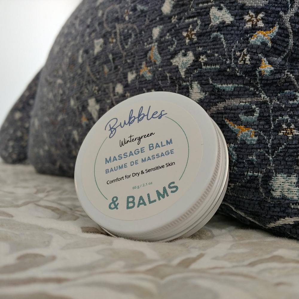 Bubbles &amp; Balms Wintergreen massage balm propped against a pillow and ready for use warming and comforting dry &amp; sensitive skin.