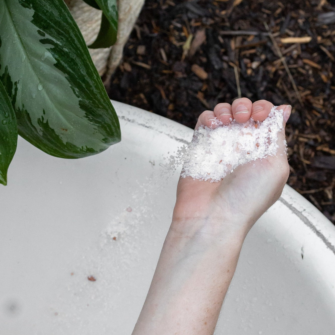 Bubbles and balms bath salts pouring from hand into tub